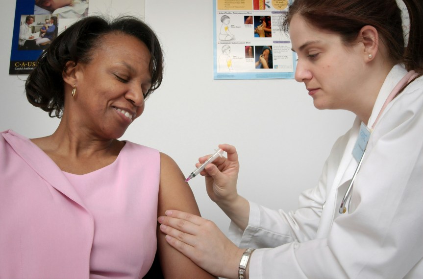 Photo of elderly woman receiving a vaccination from a doctor.